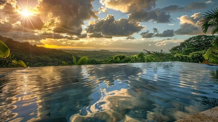 A serene infinity pool overlooking a lush tropical valley, with the sun setting behind fluffy clouds