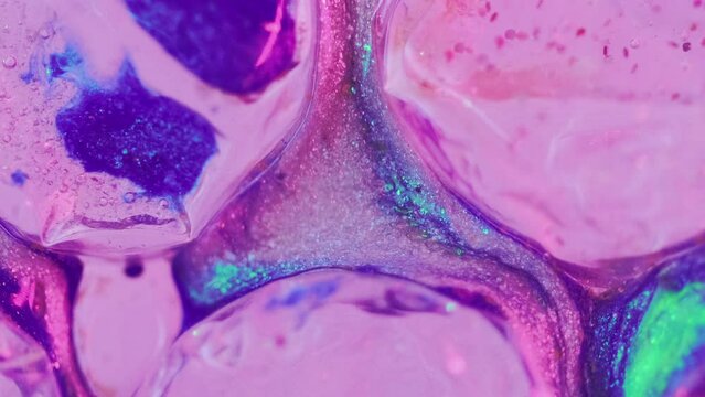Glitter paint spill. Bubble texture. Defocused neon iridescent pink blue color sparkling acrylic ink liquid wave motion cell structure abstract art background.
