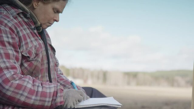 Woman works through emotional challenges by writing in journal, equine therapy