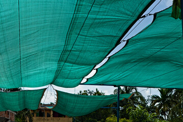 still picture of green net shade tied above the roof garden in India