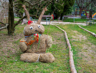 Straw Easter bunny with bowler hat. In the park.