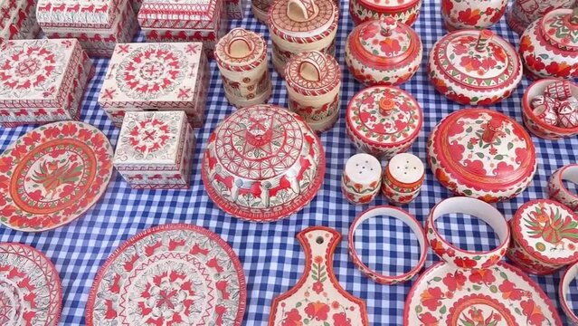 A folk crafts fair - painted wooden cutting boards, spoons, and dishware. Folk art market wooden ware showcase. Mezen painting on wood.