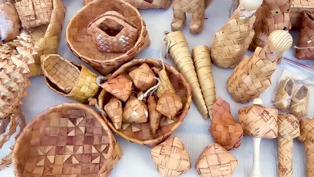А folk crafts fair featuring handmade birch bark items: lapti shoes, baskets, woven salt cellars, pencil cases, and more
