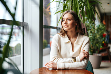 Woman Sitting at Table in Front of Window