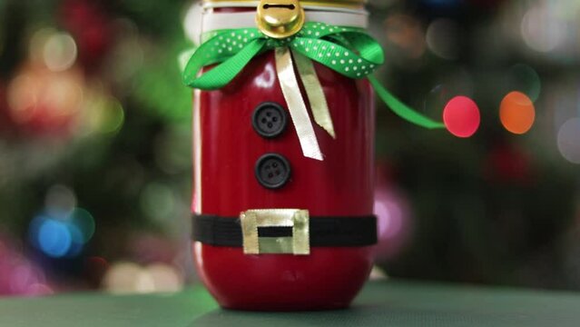Handmade decorative jar with Santa Claus outfit for Christmas. DIY crafts holiday season