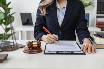 Attorney's office. Goddess of justice with scales and female lawyer working on laptop law, advice and justice concept