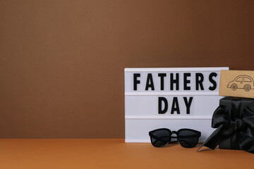Inscription on a white chalkboard father's day, on a brown background, with gifts.
