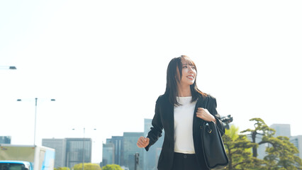 都市を走る女性ビジネスパーソン