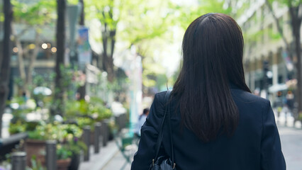 街を歩く女性ビジネスパーソンの後ろ姿