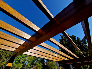 wooden construction of the bus stop, shelter of a gazebo pergola. the roof and walls are lined with...