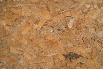 OSB sheet is made of brown wood chips pressed together into a wooden floor.