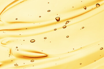 Gel serum texture. Yellow cosmetic liquid oil cream background. Transparent skincare product with bubbles smeared closeup
