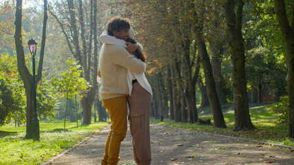 Multiethnic happy married couple in love hugging in park loving man woman enjoy embrace romantic...