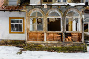 Part of an old destroyed house with broken glass windows, A glimpse of the disrepair in a fragment of an old, destroyed house.