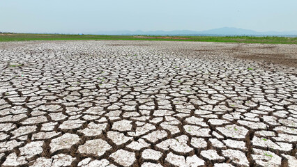 From above, cracked soil unveils intricate patterns, a solemn portrayal of arid landscapes. Drone imagery exposes nature's scars, a poignant reminder of environmental degradation.  © Punyawee