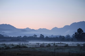 Obraz premium Explore the mystical atmosphere of dawn in a mist-shrouded valley, with mountains looming in the distance and the promise of a new day, Generative AI