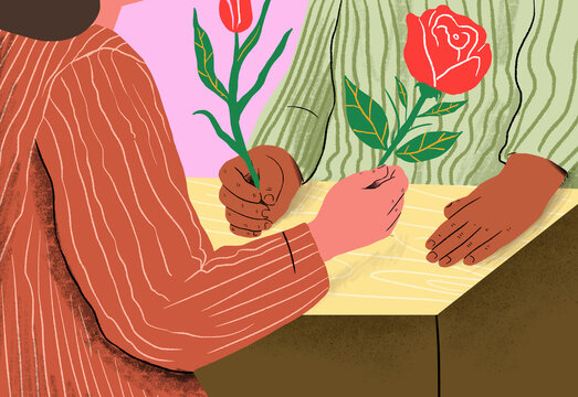 Man and woman giving flowers sitting at table