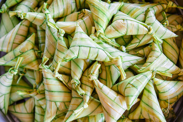 The triangular sticky rice cake wrapped with palm leaf or ketupat steamed