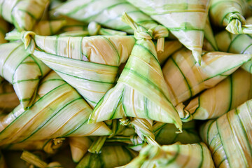 The triangular sticky rice cake wrapped with palm leaf or ketupat steamed