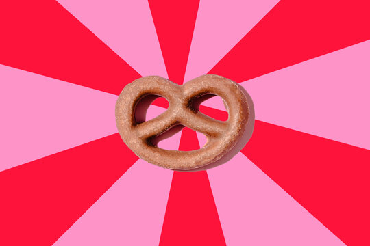 Chocolate pretzel on pink and red background