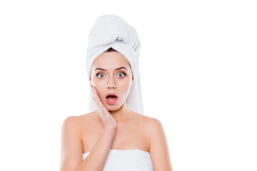 Portrait of frustrated worry woman after shower with towel on head holding hand palm on cheek with wide open mouth and eyes isolated on white background