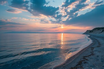 Fototapeta premium Sunset over calm sea with sandy shore