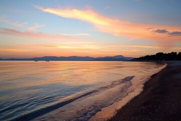Sunset over calm sea with sandy shore