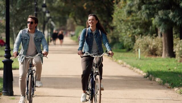 Smiling couple cycling in urban park
