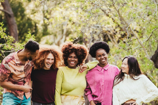 Smiling multiracial friends spending leisure time at park