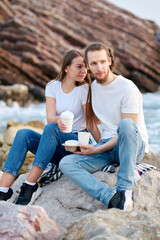 Couple Enjoying Coffee by the Sea at Sunset