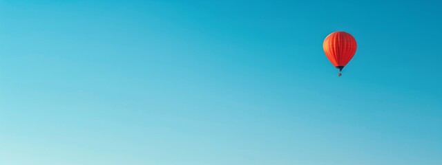 Fototapeta premium A clear blue sky with a single hot air balloon floating peacefully.