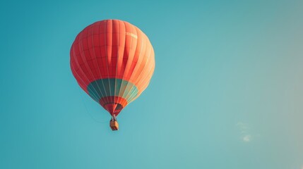 Fototapeta premium A clear blue sky with a single hot air balloon floating peacefully.