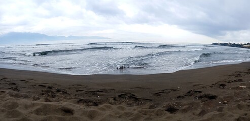 Panoramic view of the sandy beach on a cloudy day.