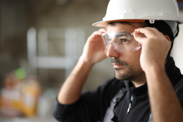 Construction worker putting protective eyeglasses