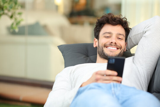 Happy man in a home terrace using phone