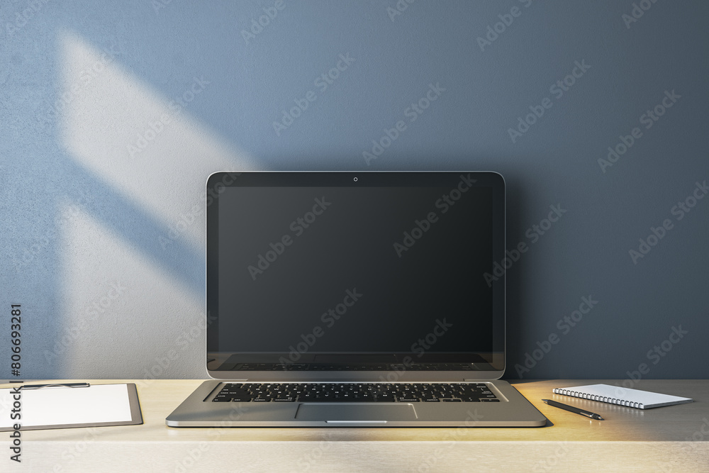 Poster close up of empty computer monitor on simple wooden desk. blue wall background. workplace concept. m