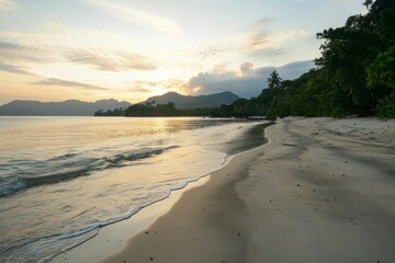Obraz premium Serene sunrise over secluded sandy beach with mountains