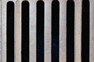 Detail of a metal grate on a sewer drain in the street
