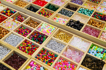 Variety of Colorful Beads in Wooden Compartment Display Boxes for Beading Workshop