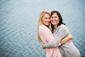 Mom and daughter on spring vacation together by lake. Mother and daugher together time in vacation...