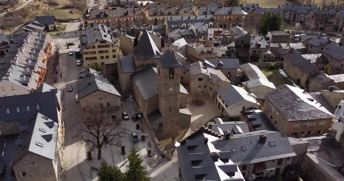 Aerial view dolly out of the Church of Santa Maria in Benasque, Romanesque-Lombard architecture, in the Aragonese Pyrenees, Spain.