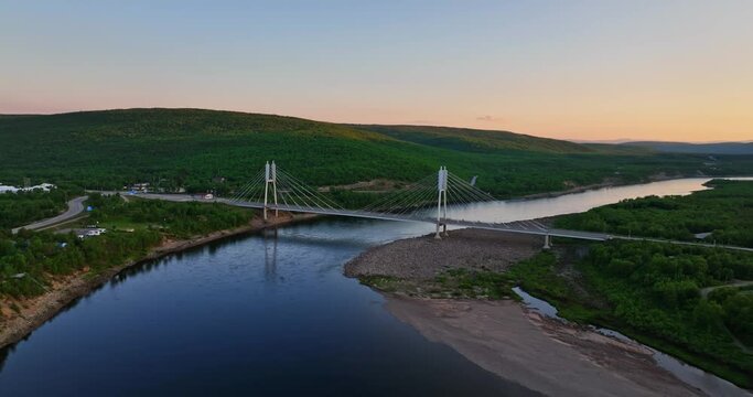 Aerial view orbiting the Sami Bridge and river, sunset in Utsjoki, Finland