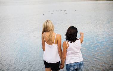 Mom and daughter on spring vacation together by lake. Mother and daugher together time in vacation...