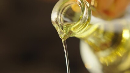 sunflower or olive oil is poured into a frying pan or into a salad for cooking in slow motion close-up - Powered by Adobe