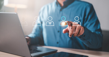 employment, executive, group, hiring, human, interview, leader, personnel, recruitment, headhunter. A man is pointing at a laptop screen. The screen has four people with a plus sign in the middle.