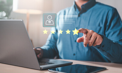 good, quality, classification, positive, advertisement, experience, evaluation, feedback, opinion, performance. A man is using laptop with a star rating system on screen. He is pointing at the stars.