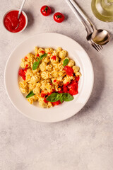 Sacсhettini pasta in a plate with tomato sauce.