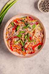 Bowl of rice noodles with vegan soy meat and vegetables.