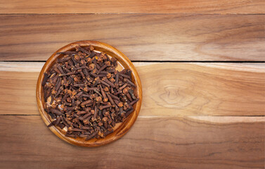 Cloves in a bowl on a wooden