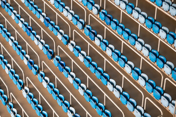 Blue Stadium Seats in Diagonal Rows, Empty Sports Arena Concept. Symmetrical rows of blue seats in an empty stadium, creating a visually captivating pattern of lines and color.